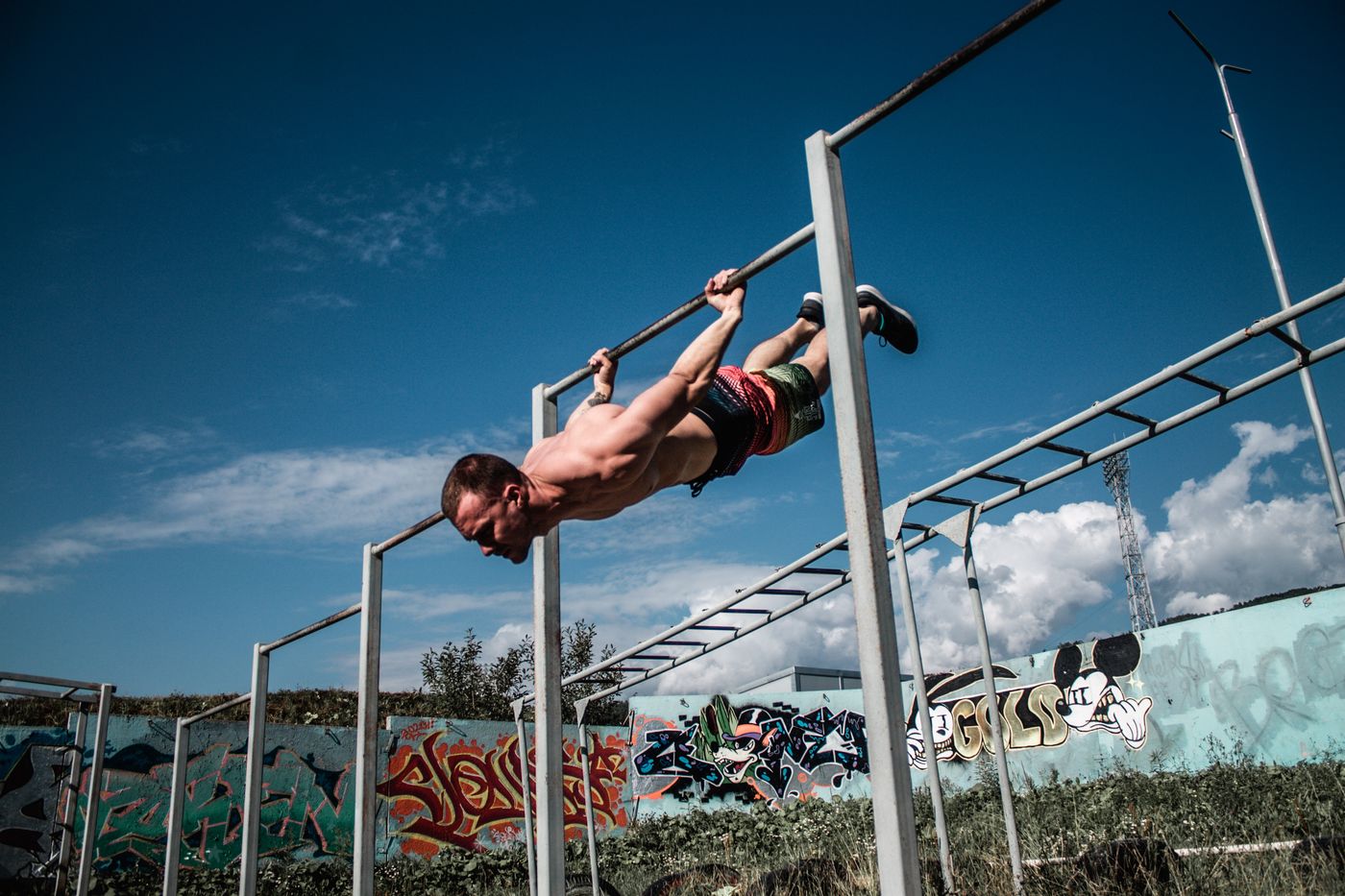 Athlete training a calisthenics hold on parallel bars